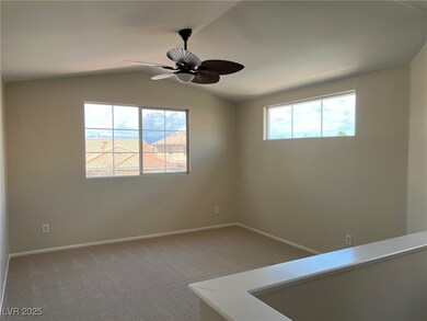 Carpeted empty room featuring ceiling fan, lofted