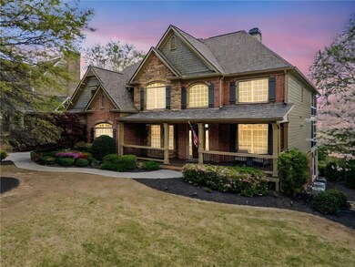 View of front of property featuring a front yard, brick siding, a chimney, and covered porch