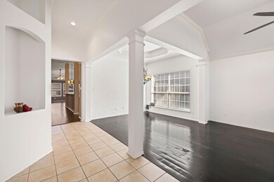 Unfurnished room featuring decorative columns, cei