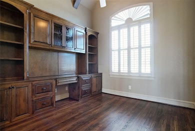 Study features oakwood finished floor, built-in study wall unit, white plantation shutters, cedar beams and custom baseboards