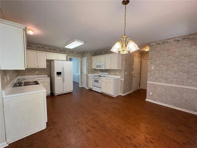 Kitchen featuring white appliances, dark wood-styl