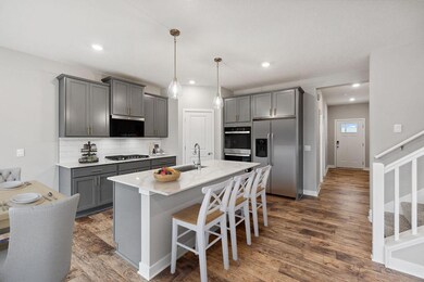 Harbor Gray cabinet, brass hardware and quartz counters make for a lovely kitchen. Photo virtually staged.