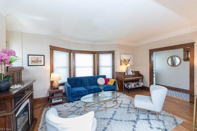 Living room with built-in leaded glass cabinets, bay window & hardwood floors