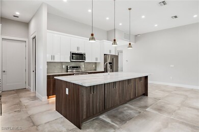 Kitchen featuring a large island with sink, light