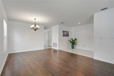 Tiled Foyer next to the formal living/formal dining combo with new floor, blinds and lighting fixture.