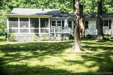 Rear view of house featuring a sunroom and a yard