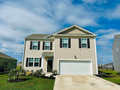 View of front facade with concrete driveway and a garage