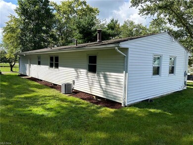 View of home's exterior with a yard and central AC