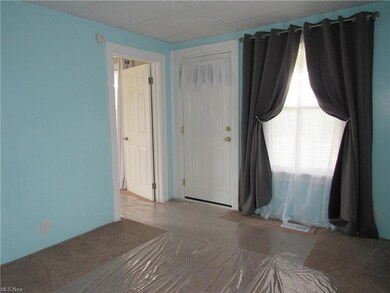 Light colored carpet. Front window. Drop ceiling
