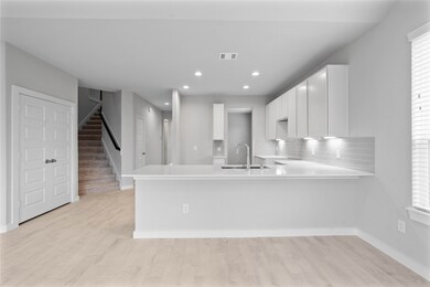 The open concept living room and kitchen makes for a great way to keep the party going and never miss a beat! Gather the family together in good conversation while preparing a fabulous meal in this breathtaking kitchen! Featuring high ceilings, light stained wood cabinets, granite countertops, SS appliances, modern tile backsplash, recessed lighting, and kitchen island with ample counter space!