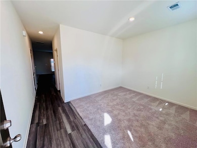 Unfurnished room featuring wood finished floors, baseboards, visible vents, and recessed lighting