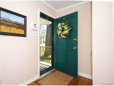 The foyer is welcoming with hardwood floors, a coa