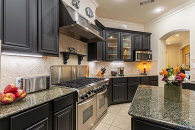 Kitchen featuring wall chimney range hood, decorat