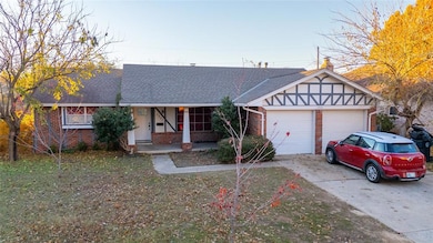 Ranch-style house with a garage and a front lawn