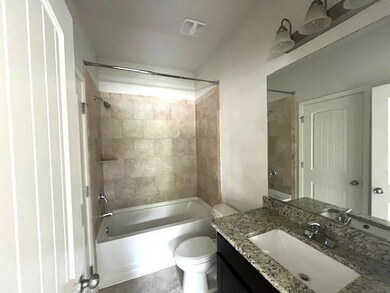 Bathroom with toilet, shower / tub combination, and vanity