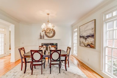 Dining area featuring a chandelier, plenty of natural light, light wood-style flooring, and crown molding