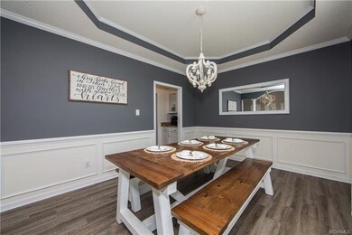 This spacious dining room features tray ceiling, updated lighting, chair rail and picture frame moulding, and gorgeous luxury vinyl plank flooring for a modern look with easy care and cleanup!