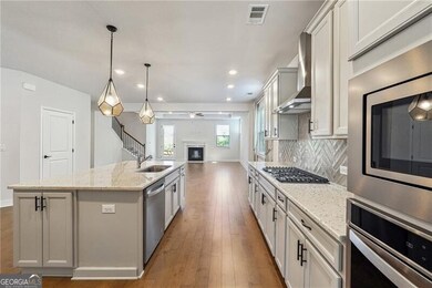 Kitchen with wall chimney exhaust hood, a sink, op