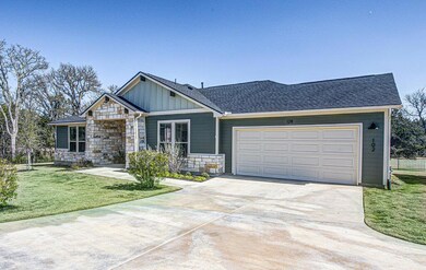 View of front of property featuring a garage, a f