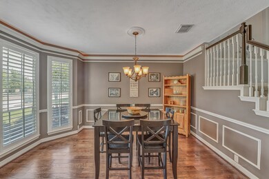 FORMAL DINING ROOM - with a bay window that looks onto the front yard, crown molding with lighting and wood flooring.