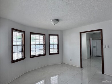 Unfurnished room featuring baseboards, a textured ceiling, and light tile patterned floors