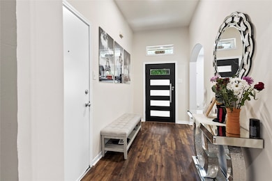 Welcoming foyer featuring elegant wood flooring, a