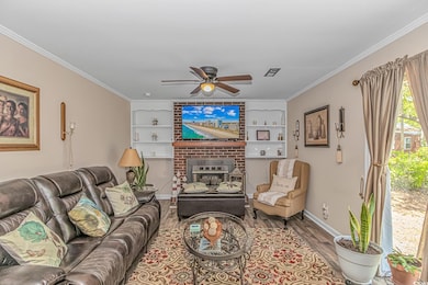 Living area with wood finished floors, crown moldi