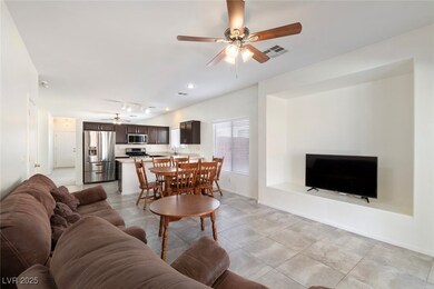 Family room with airy grey floors, ceiling fan, cu