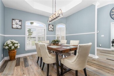 Dining area with a tray ceiling, baseboards, a cha