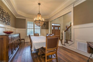 The spacious dining room offers tray ceiling, over sized wainscotting, and plantation shutters. Perfect space for a family meal or entertaining friends!
