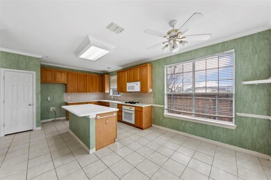 Kitchen with crown molding, white appliances, a he