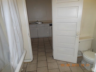 Full bathroom with light tile patterned floors, vanity, and a shower with curtain