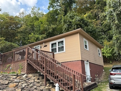 View of front of home featuring stairs and a wooden deck