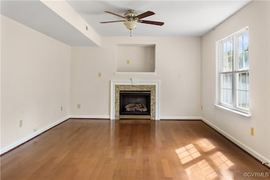Unfurnished living room featuring baseboards, a ce