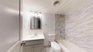 Full bathroom featuring toilet, vanity, and tiled 