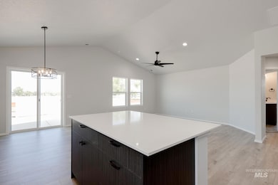 Kitchen with a kitchen island, open floor plan, light wood-style floors, recessed lighting, and decorative light fixtures