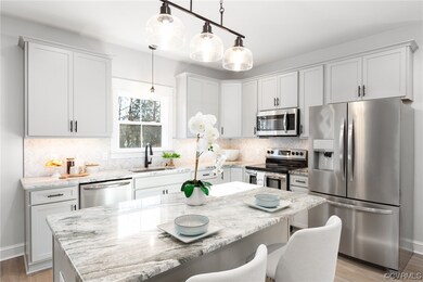 Kitchen with a center island, a breakfast bar, pendant lighting, and stainless steel appliances