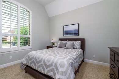 Carpeted bedroom featuring vaulted ceiling and mul