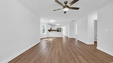 Unfurnished living room featuring a ceiling fan and wood finished floors
