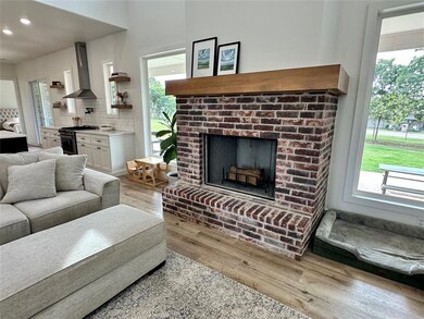 Living room featuring light wood-style floors, healthy amount of natural light, and a fireplace