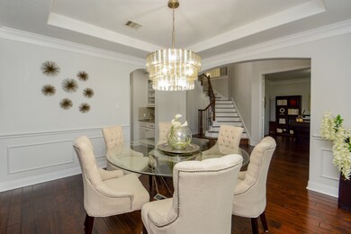 An artist couldn't have painted this scene more beautifully! Here is a wonderful view of the dining space, previously referenced, as it opens onto the home's glorious staircase; other spaces off the main hallway, and offers a peek into the home's amazing chef's kitchen (left).
