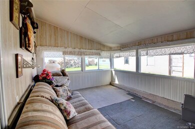 Huge enclosed porch is attached to the house and g