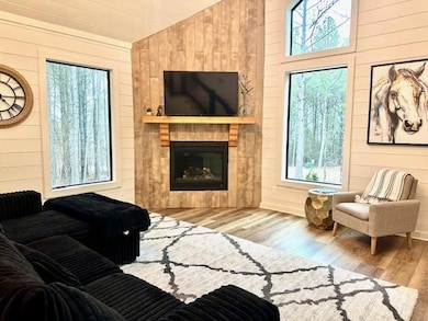Living room with wooden walls, a tiled fireplace, 