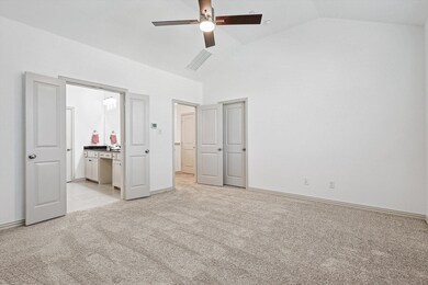 Primary bedroom featuring light carpet, ensuite ba