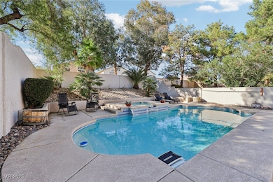View of pool featuring a patio, a fenced backyard, and a pool with connected hot tub