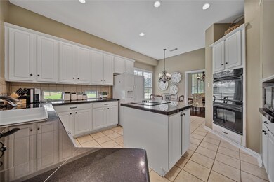 A chef's dream kitchen with granite, island with cooktop, and double ovens!