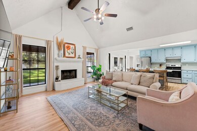 Bright and airy living room with vaulted ceilings and a painted-brick fireplace