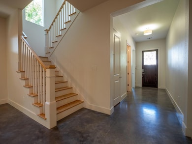 Foyer with finished concrete floors and stairs