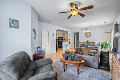 Living room featuring ceiling fan with notable cha