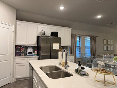 Kitchen with white cabinets, appliances with stainless steel finishes, recessed lighting, light stone countertops, and open floor plan